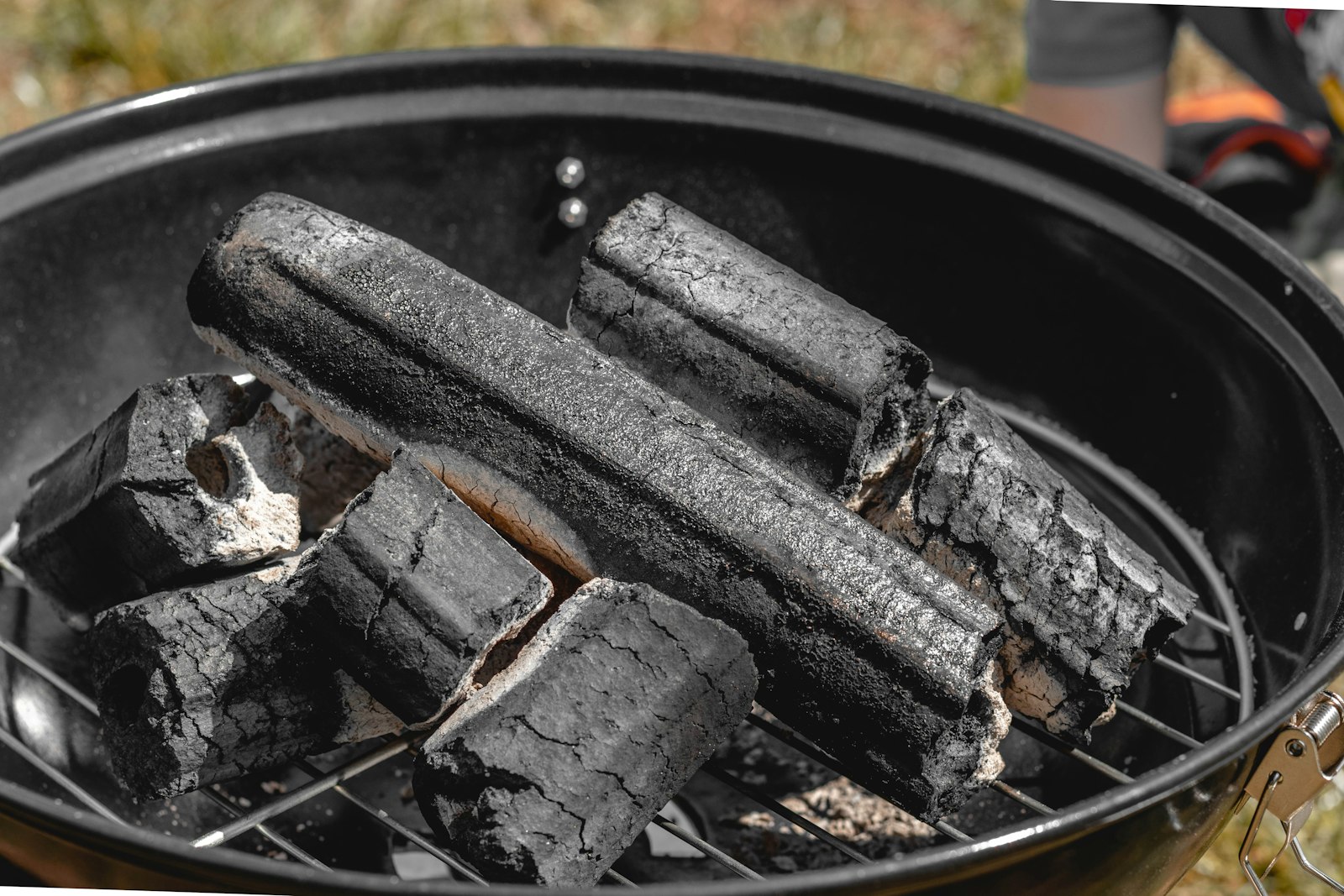 Charcoal briquettes burning in a small kettle grill – small portable charcoal grills compared